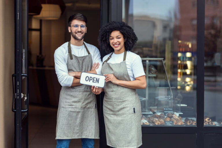 two people outside of a bakery holding an 