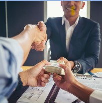 People shaking hands over a desk