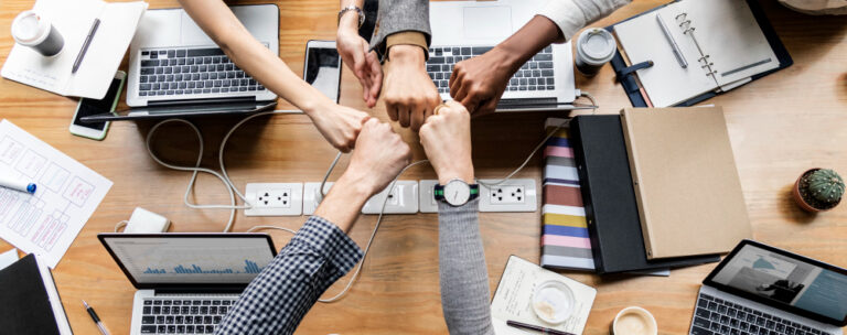 Hands meeting in center of table